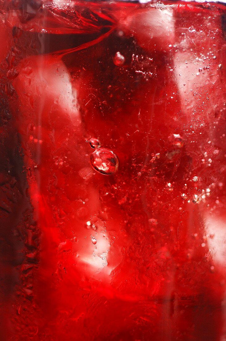Roter Fruchtsaft mit Eiswürfeln, bildfüllend