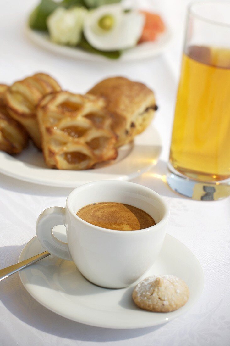 Eine Tasse Espresso, Apfelsaft und Gebäck