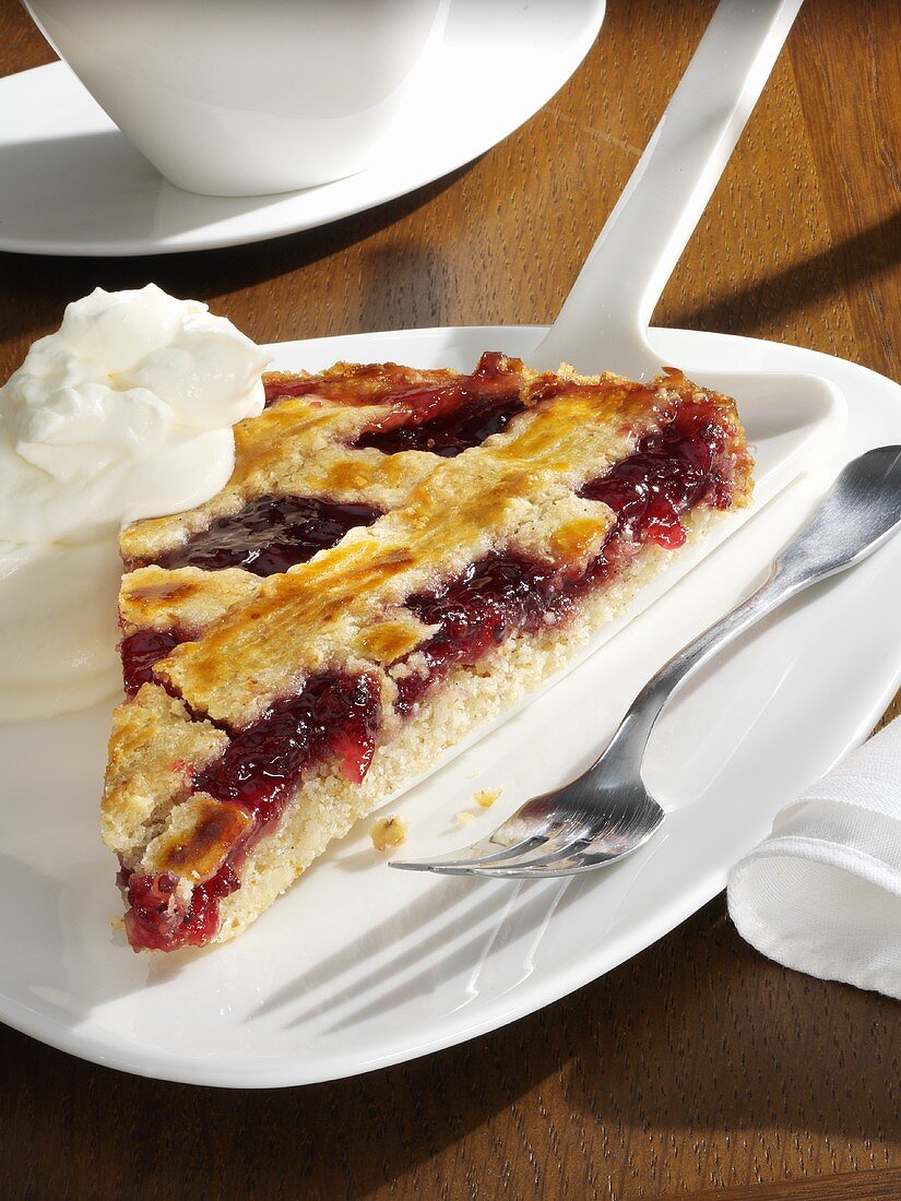 A piece of Linzer torte with whipped cream
