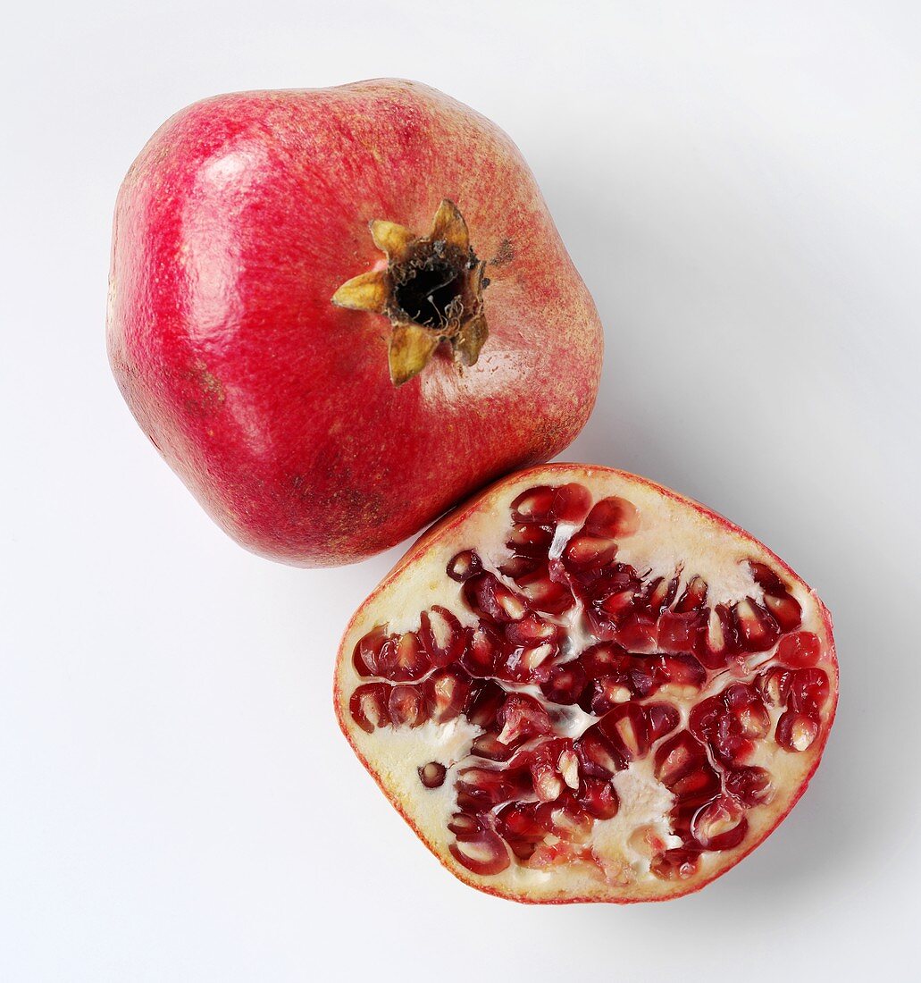 Whole pomegranate and half a pomegranate
