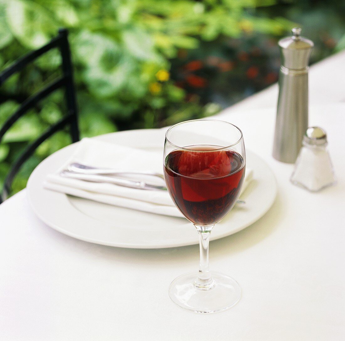 Gedeck mit einem Glas Rotwein im Freien