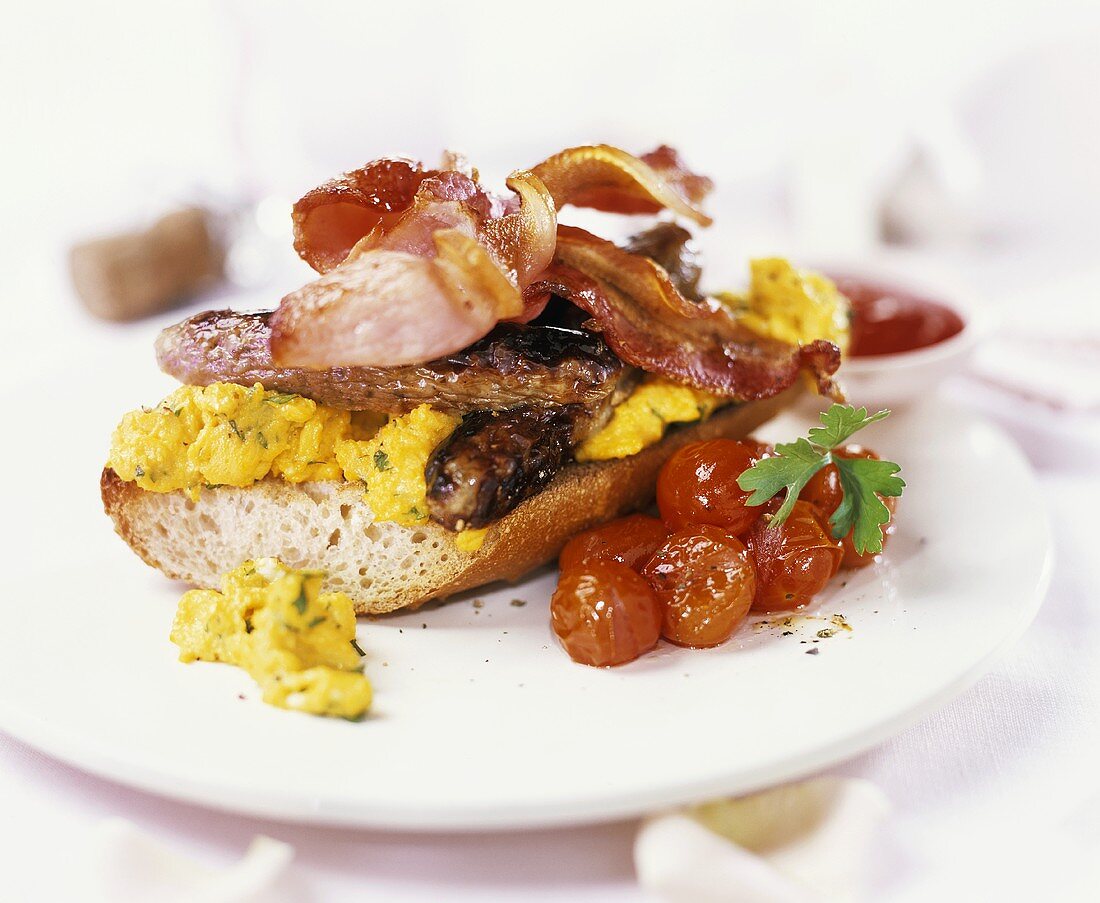 Bageutte mit Rührei, Würstchen, Speck und Tomaten