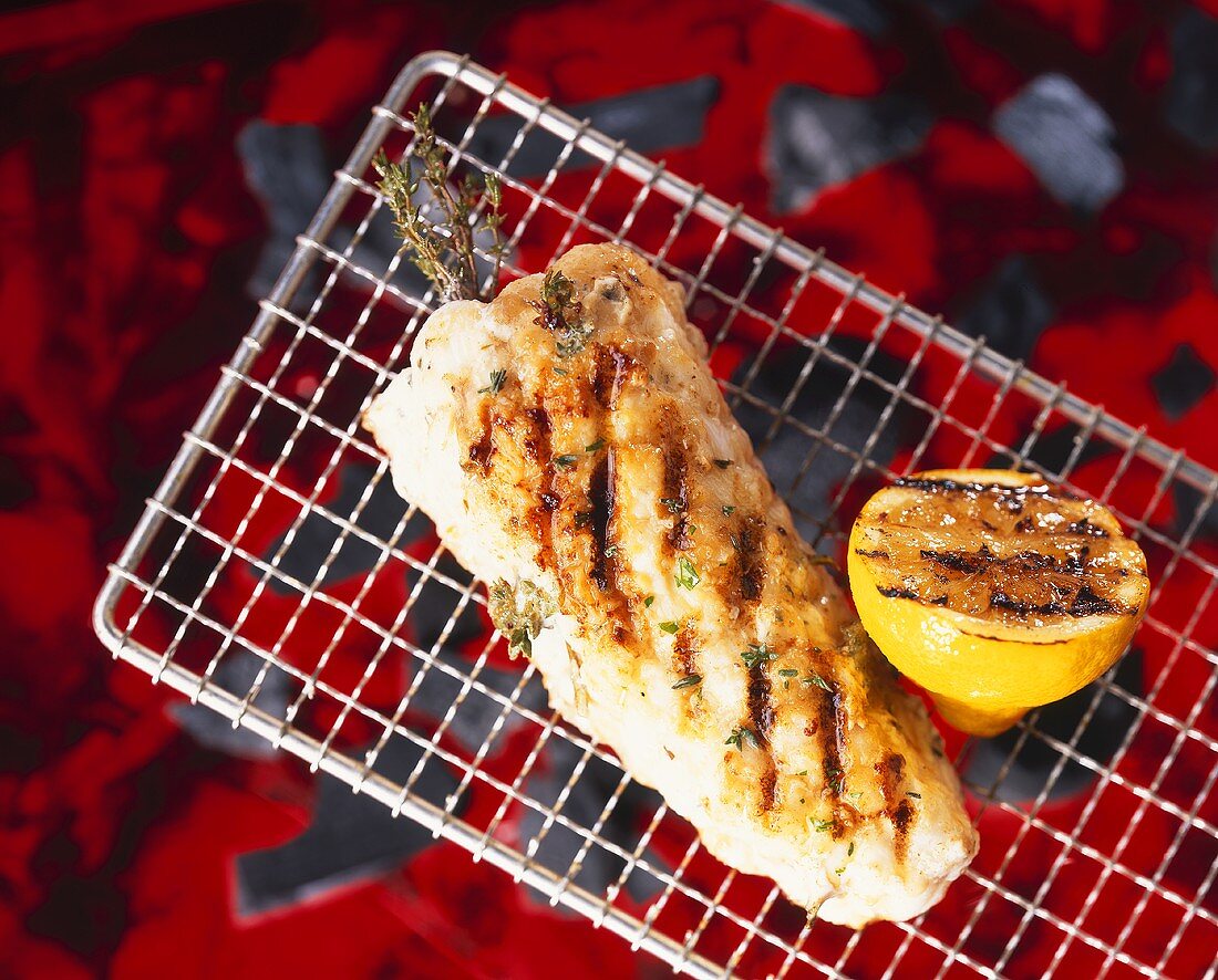 Monkfish on a barbecue with herbs and lemon