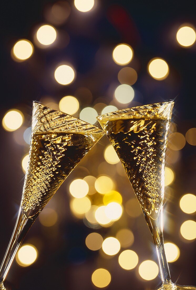 Two glasses of sparkling wine being clinked together