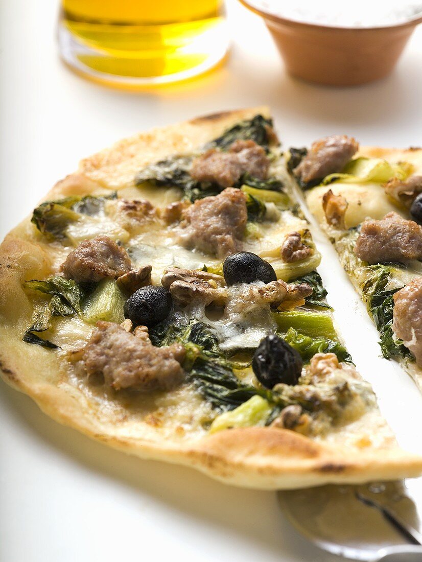 Pizza mit Hackfleisch, Oliven, Spinat und Käse (halbiert)