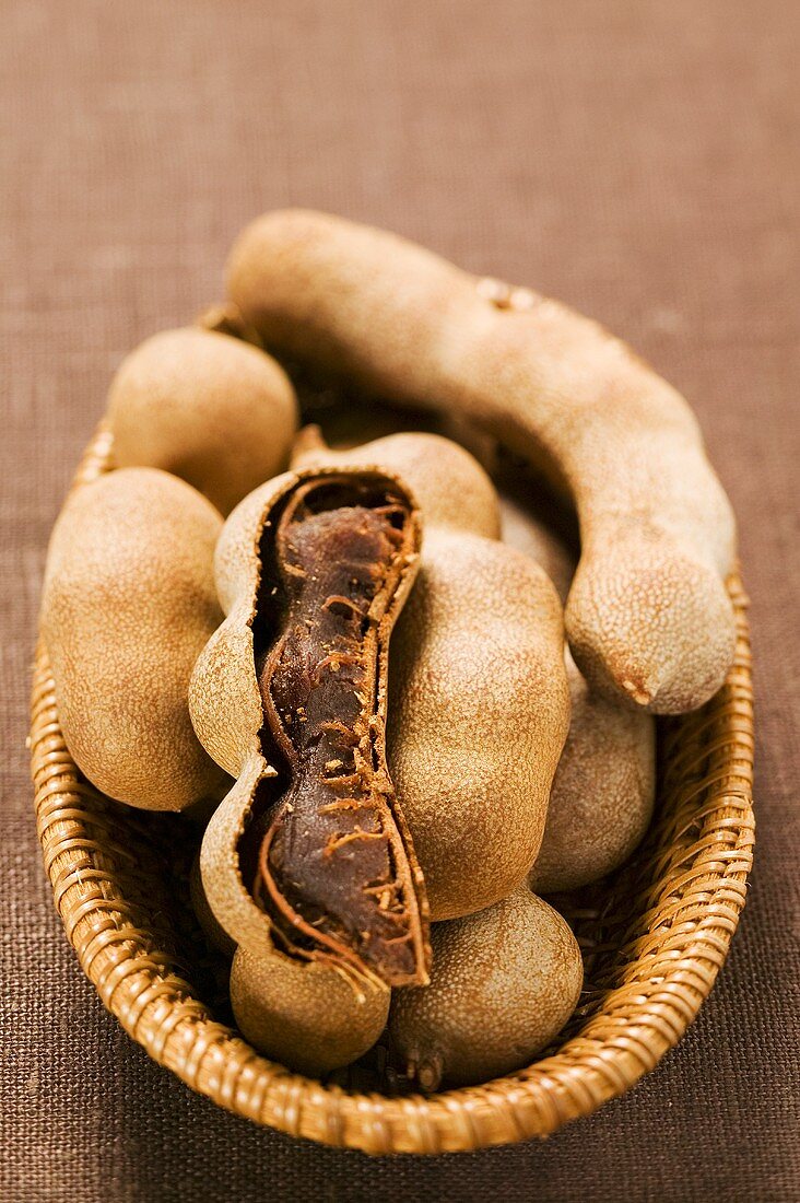 Several tamarinds, one opened, in basket