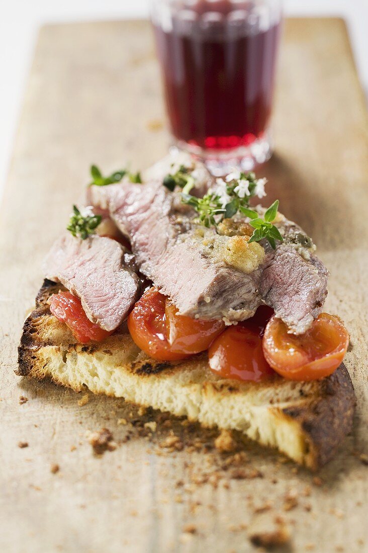 Beef steak with cherry tomatoes on toasted bread