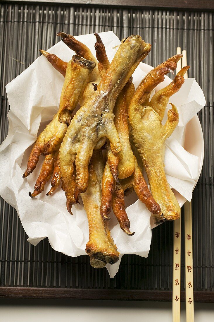 Deep-fried chicken feet on paper (Asia)