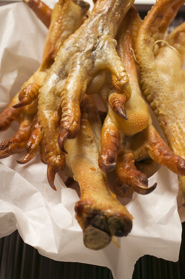 Deep-fried chicken feet on paper (Asia)