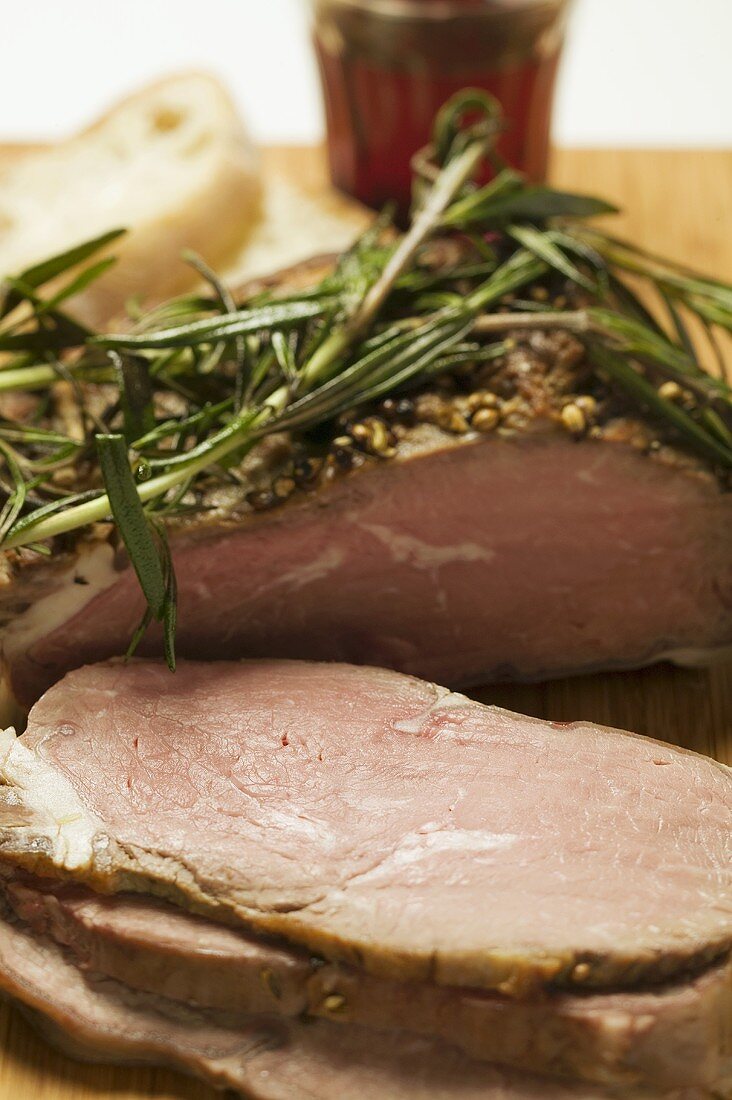 Roast lamb with rosemary, slices carved, white bread, red wine