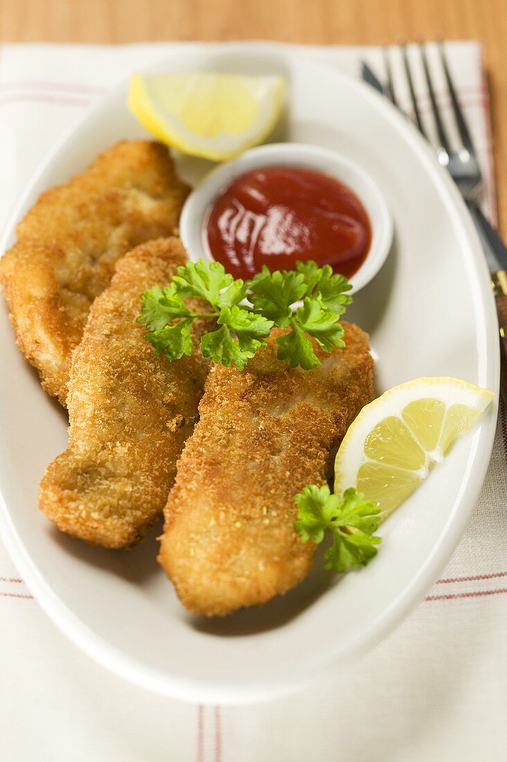 Fischnuggets mit Ketchup und Zitronen