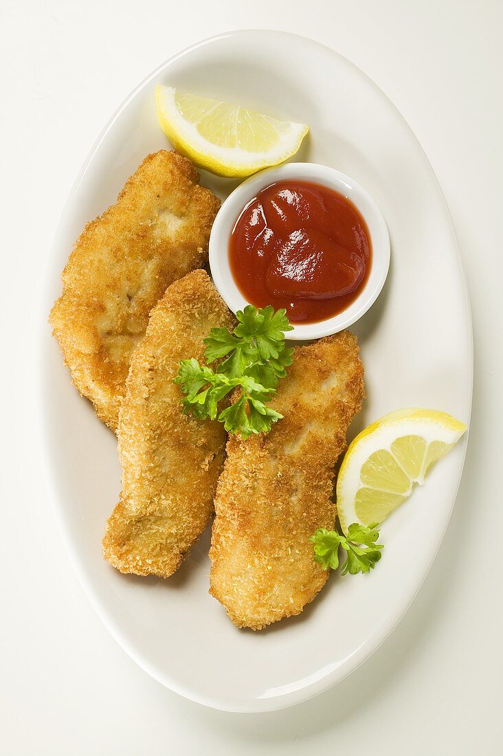 Fischnuggets mit Ketchup und Zitronen