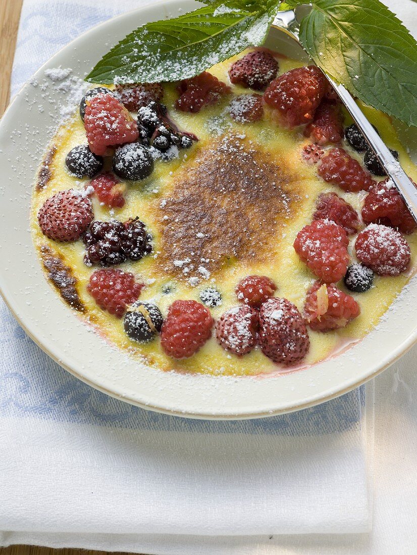 Crème brûlée with berries and icing sugar