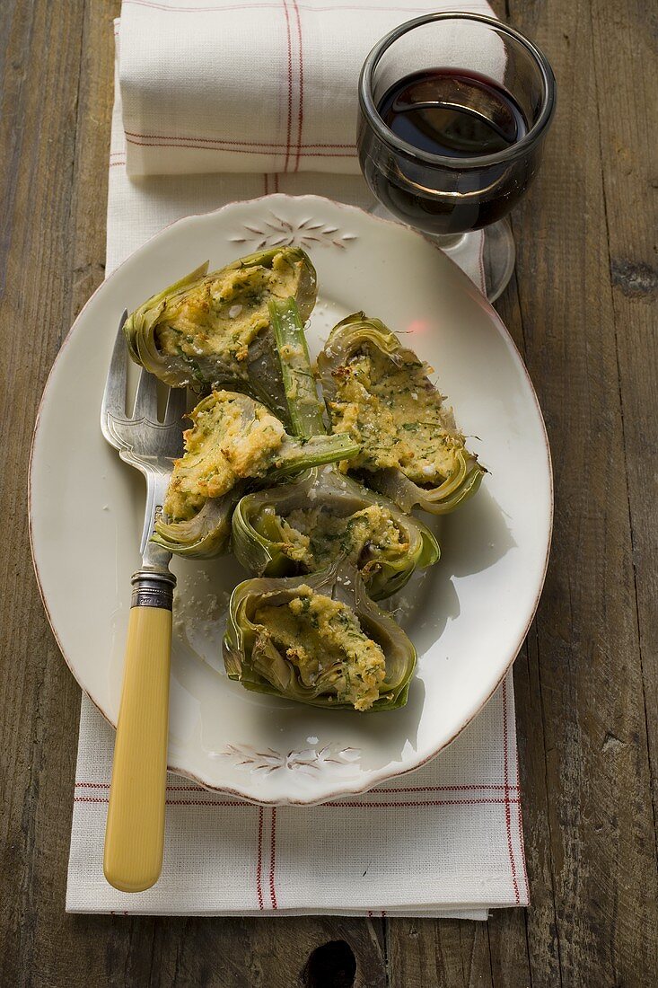 Stuffed artichokes with gratin topping, glass of red wine