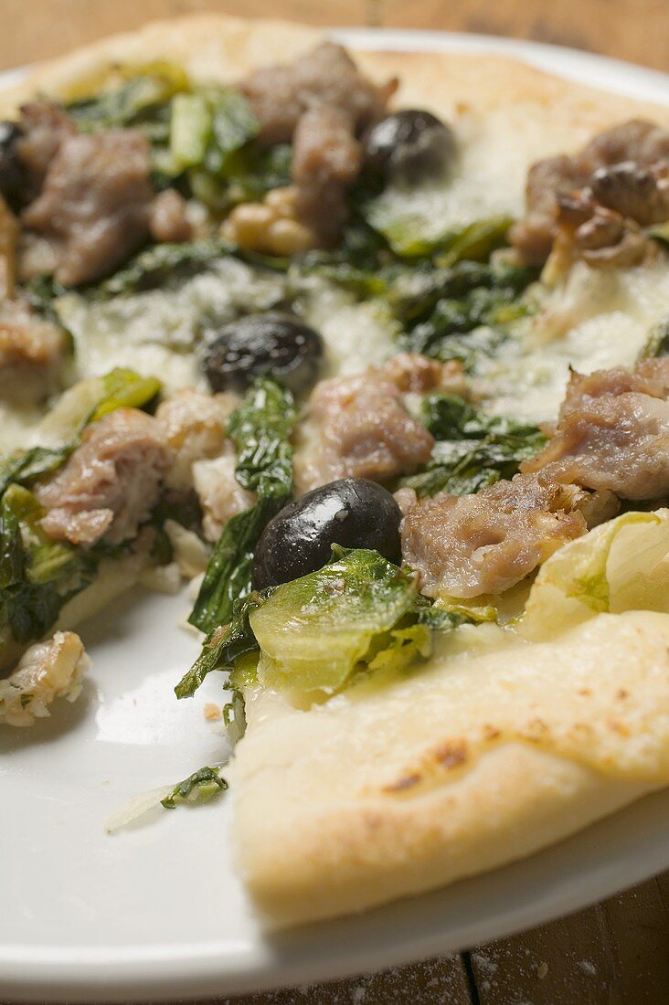 Pizza with tuna, chard and olives, a slice taken