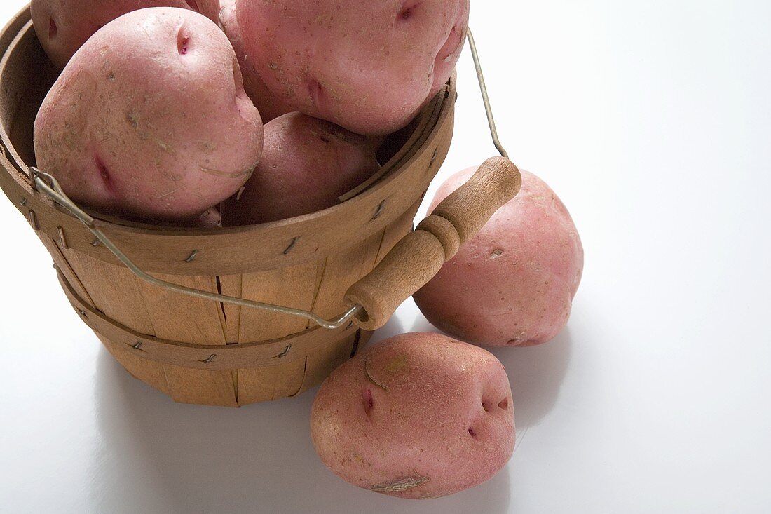 Rote Kartoffeln in und neben Spankorb
