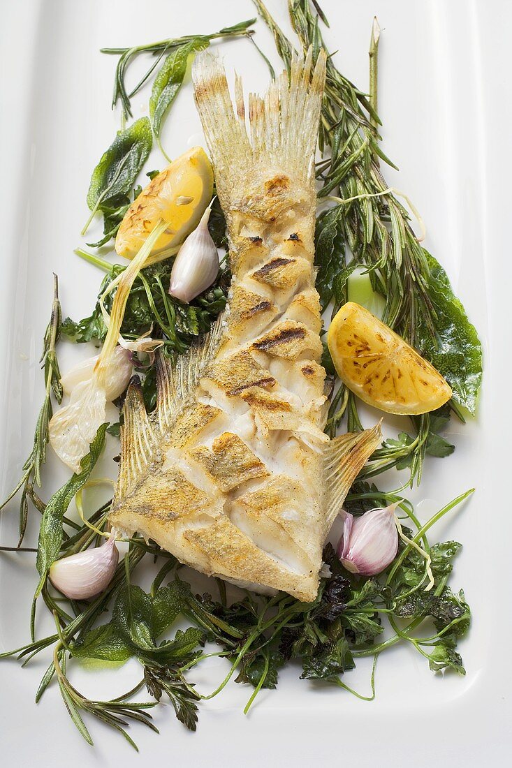 Fried sea bass with herbs, garlic and lemon