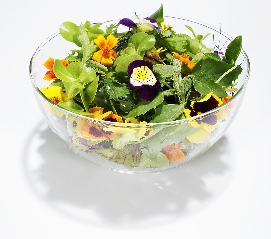 Blattsalat mit Blüten in Glasschüssel