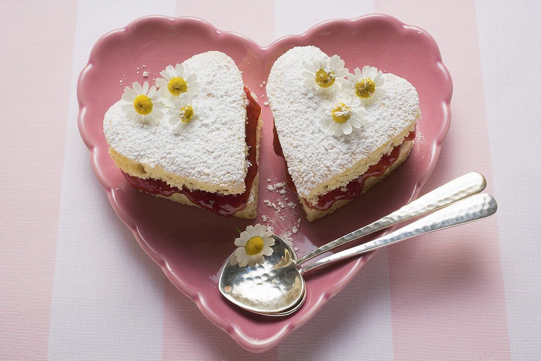 Heart-shaped cakes with jam, icing sugar, daisies