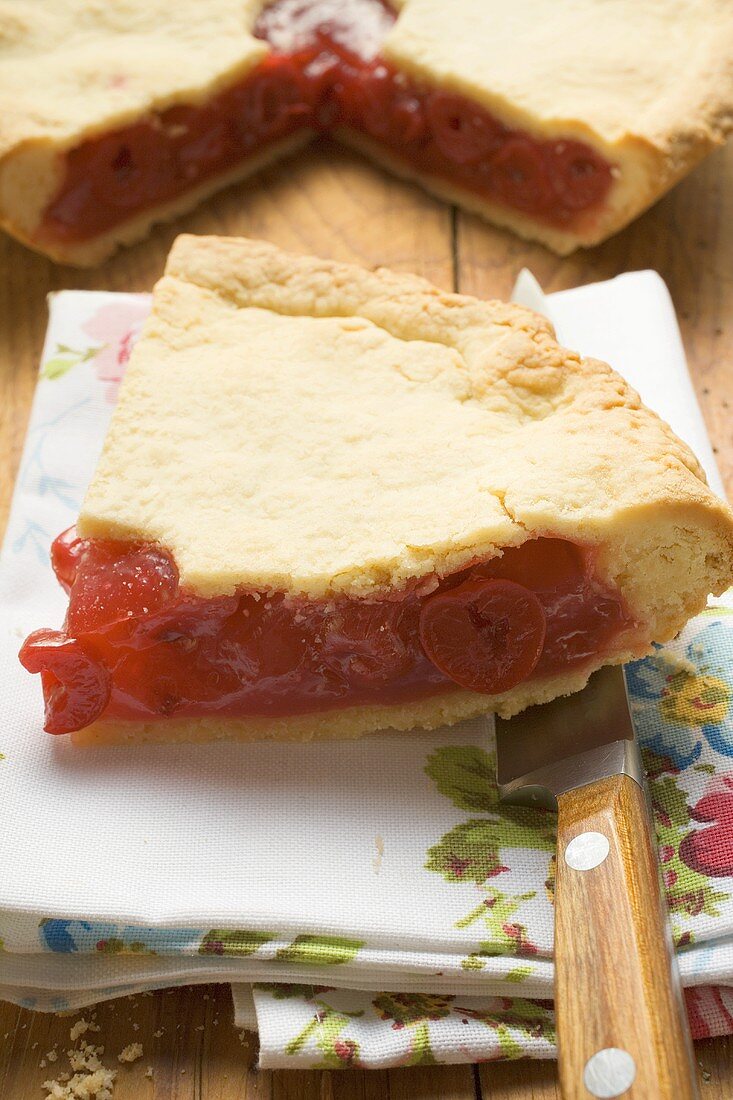 Cherry Pie, angeschnitten, mit Stück auf Stoffserviette