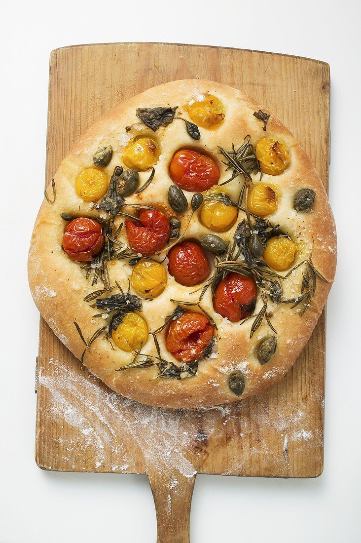 Pizza with cherry tomatoes, capers and rosemary