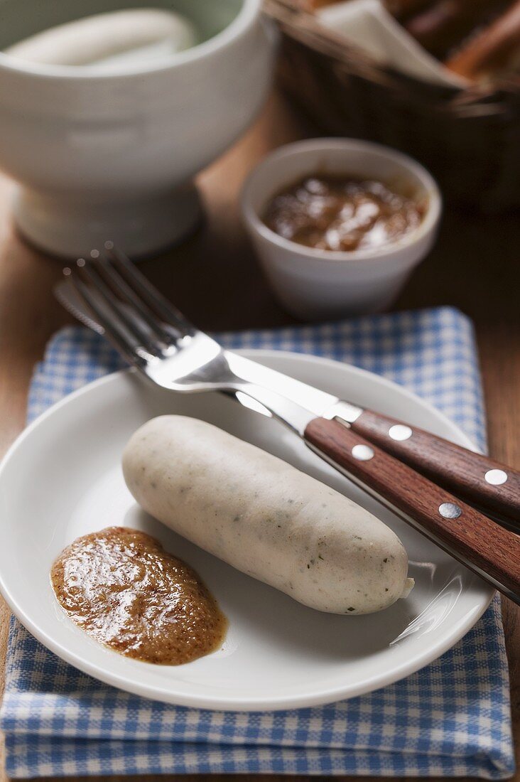 Gekochte Weisswurst mit Senf auf Teller