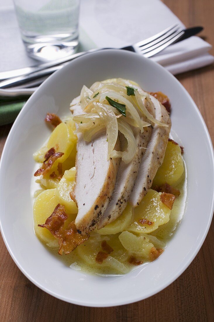 Potato salad with bacon, chicken breast and onions