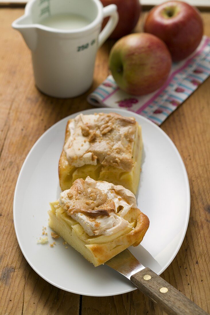 Two pieces of apple meringue cake, fresh apples & milk