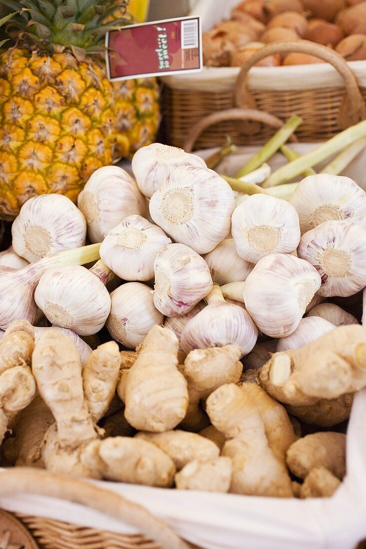 Garlic bulbs, ginger and pineapples at a market