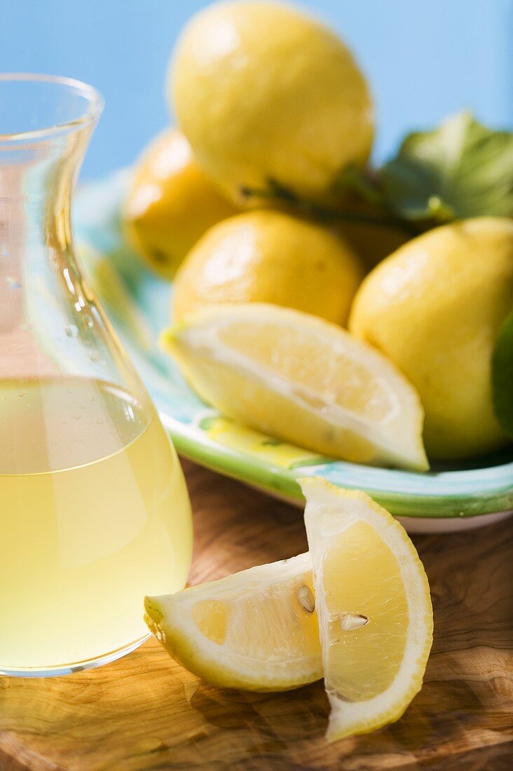 Several lemons with leaves, lemon wedges, lemon juice