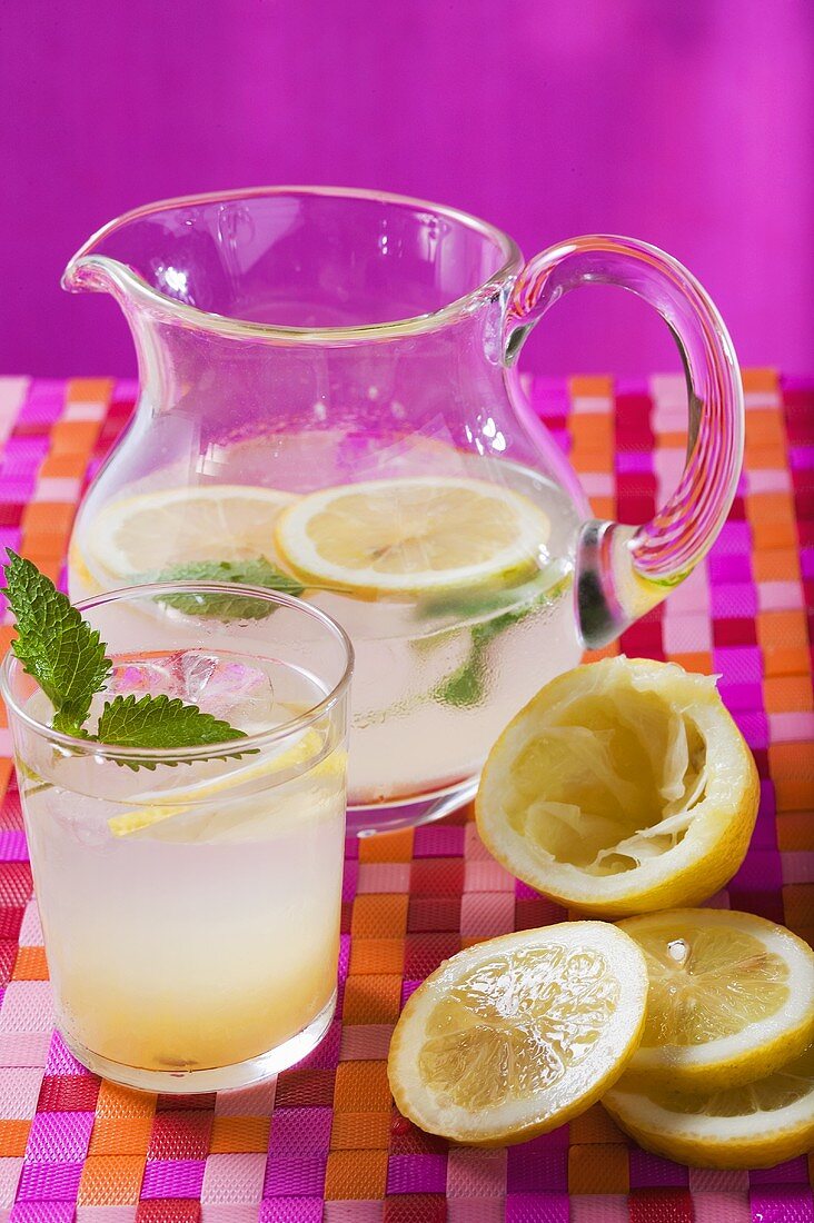 Zitronenlimonade im Glas und Krug