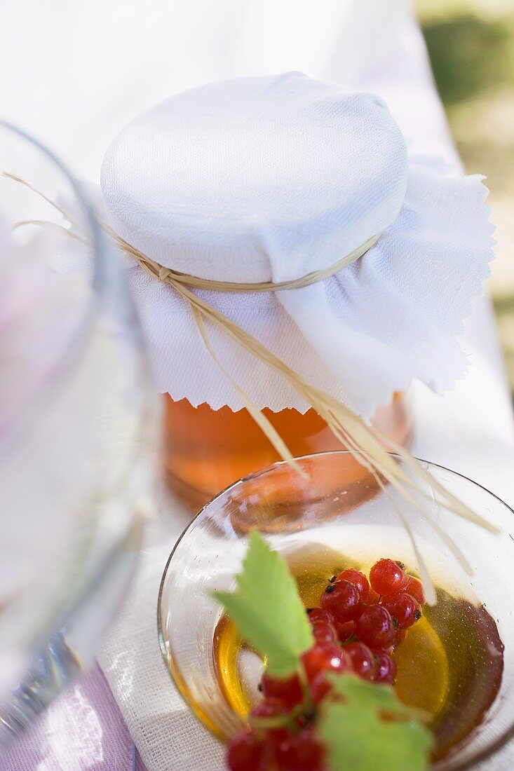 Honey and redcurrants on table in the open air