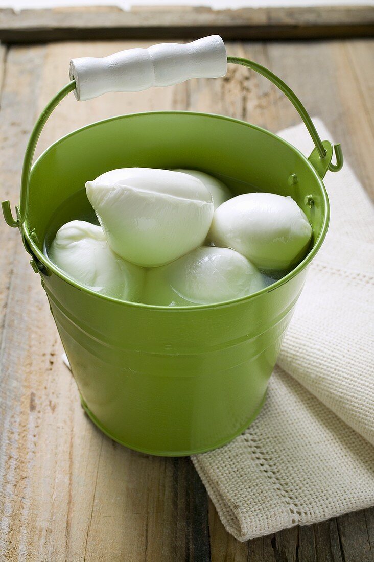 Mozzarella with brine in green bucket