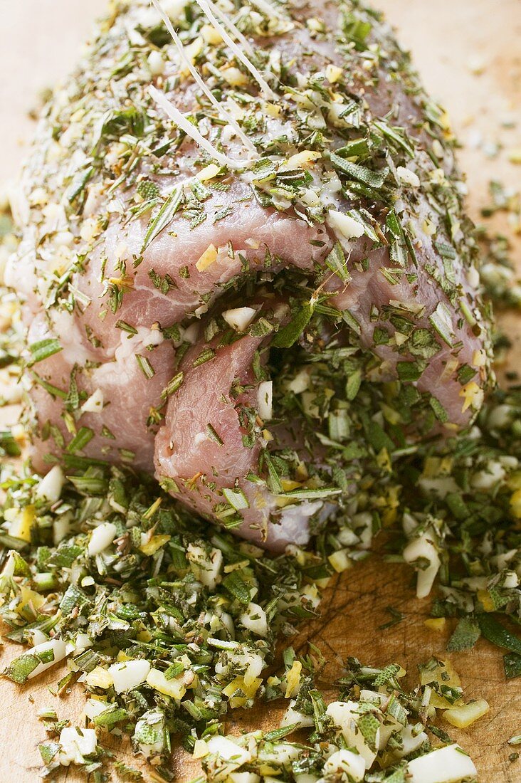 Raw pork roll with chopped herbs