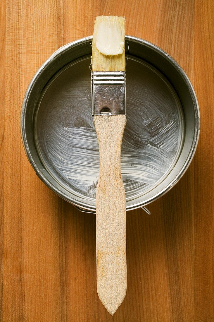 Pastry brush with butter on baking tin