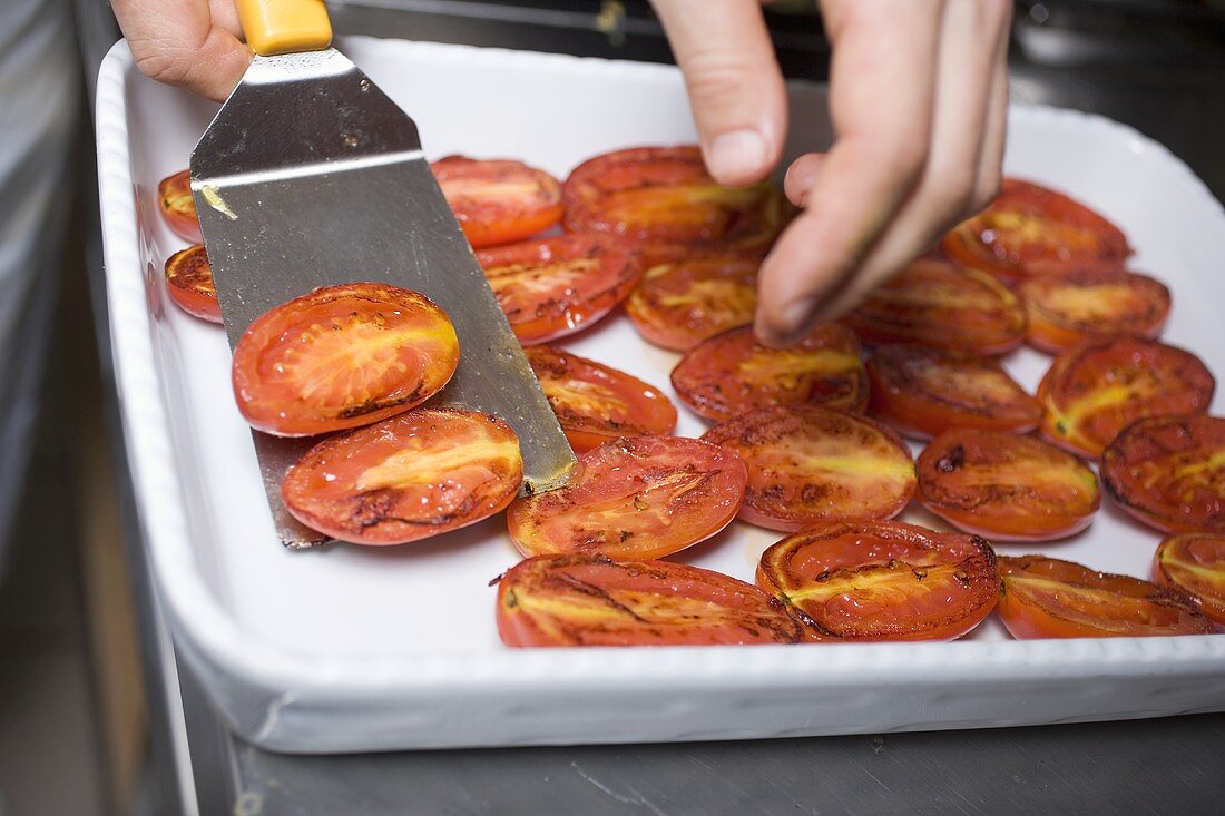Gebratene Tomaten auf Platte legen