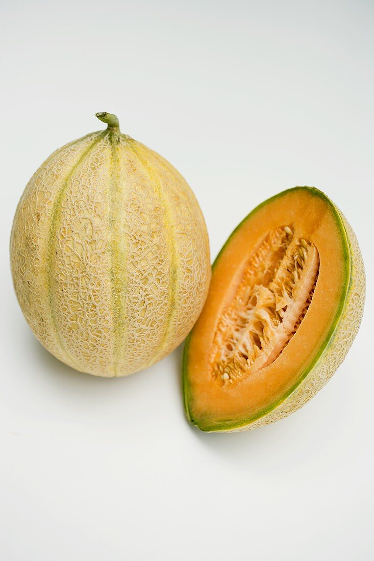 Whole and half of a cantaloupe melon