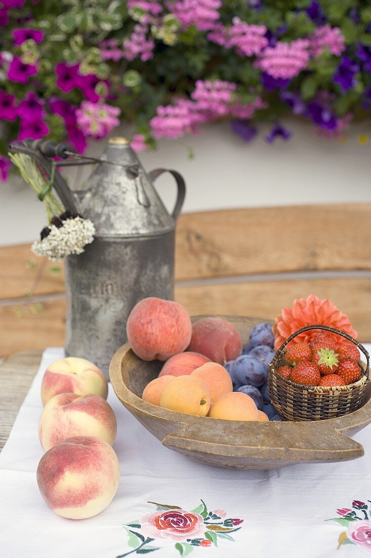 Sommerliches Obststillleben auf Tisch vor dem Haus