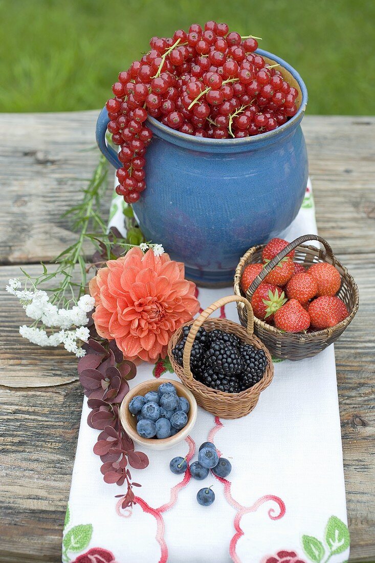 Summer berry still life on rustic table out of doors
