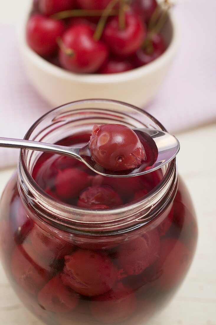 Cherry compote in jar and on spoon