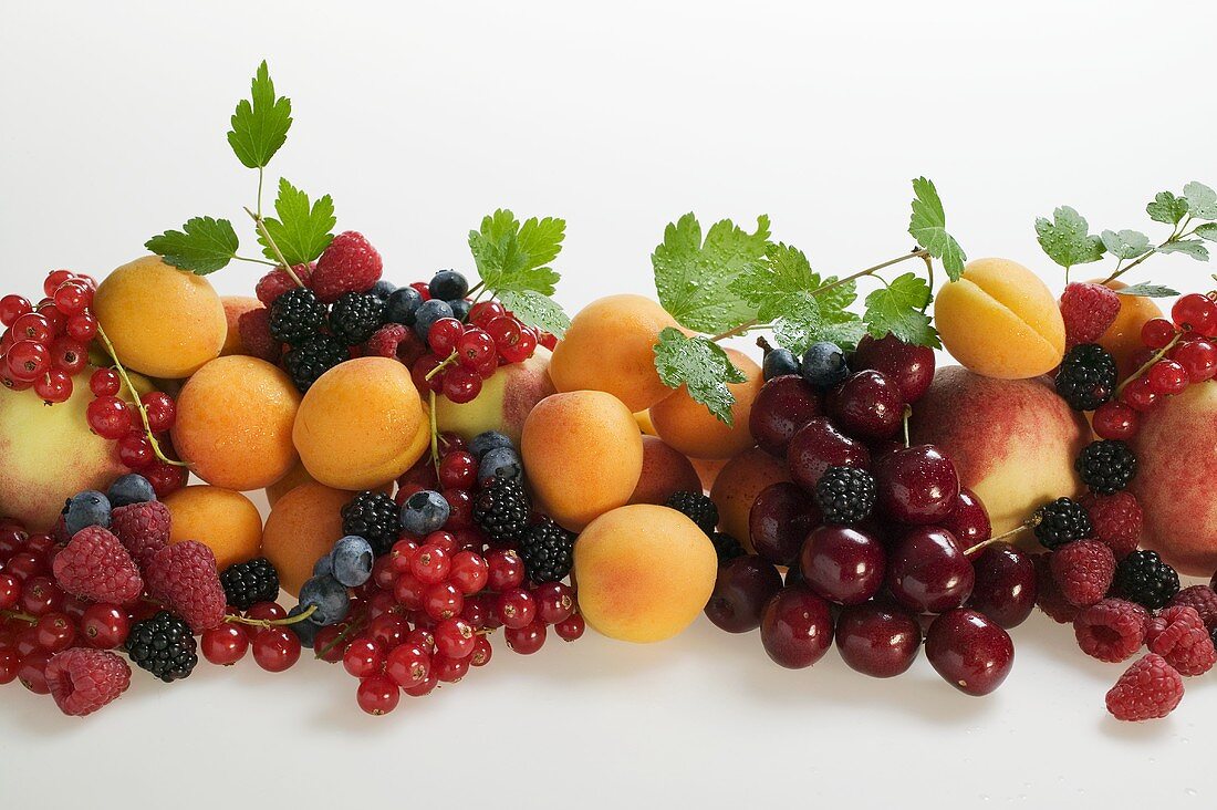 Obststillleben mit Steinobst, Beeren und Blättern