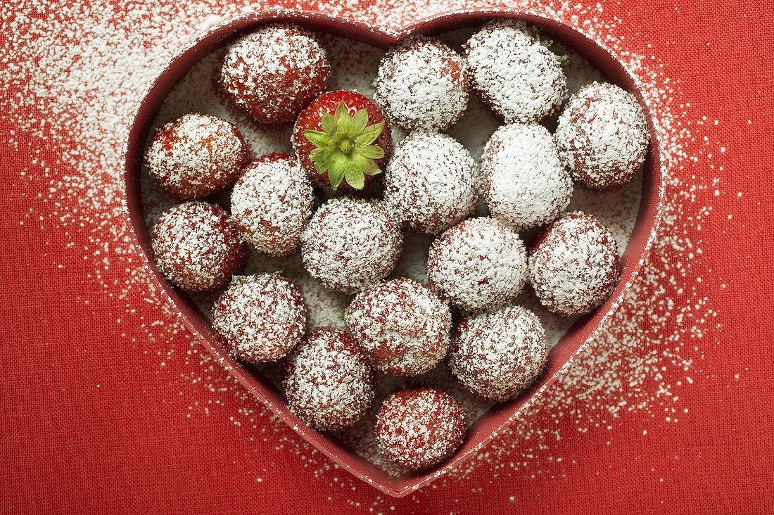 Gezuckerte Erdbeeren in herzförmiger Schale