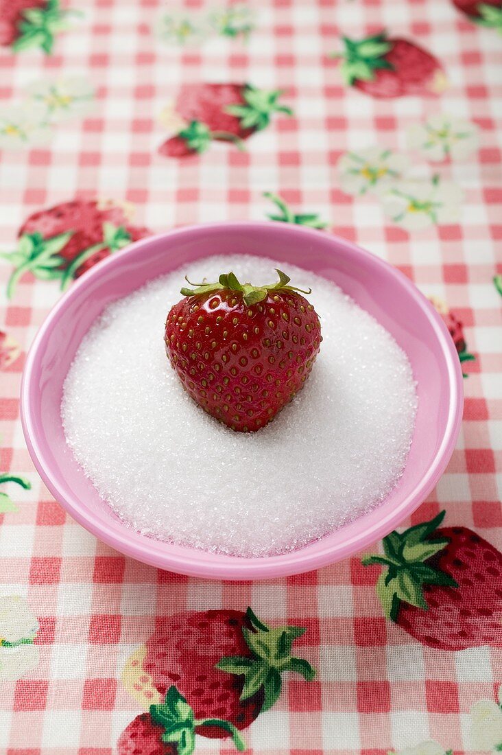 Erdbeere in einem Schälchen Zucker