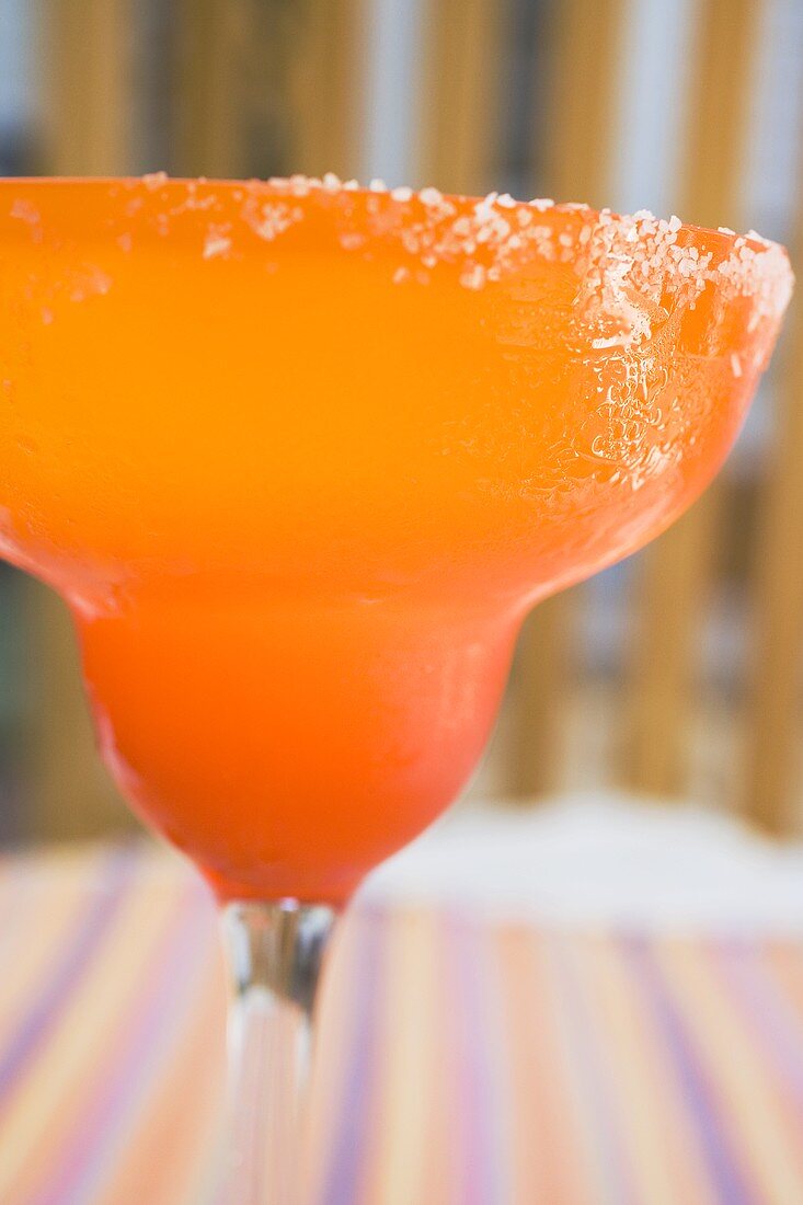 Margarita in orangefarbenem Glas mit Salzrand