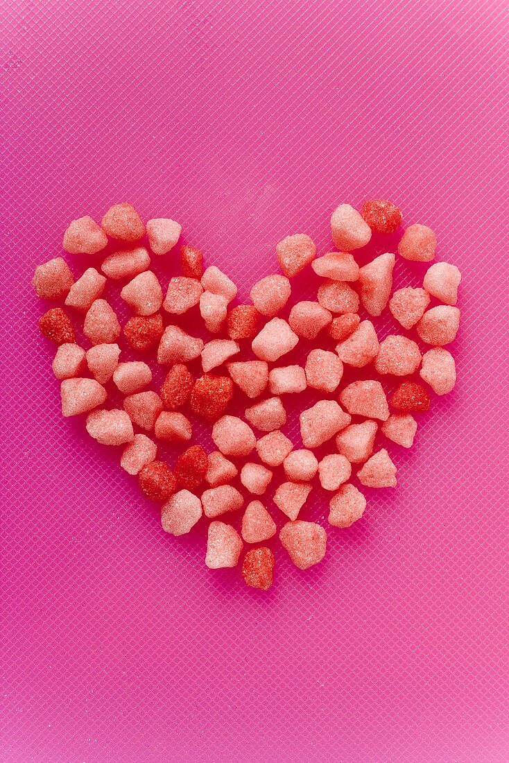 Small pink sweets arranged in a heart shape (solid)