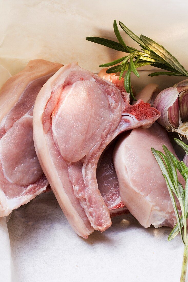 Raw pork chops, rosemary and garlic