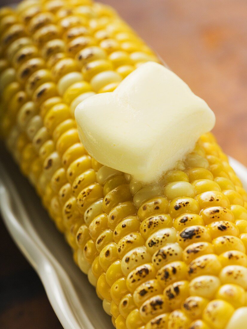 Gegrillter Maiskolben mit Stück schmelzender Butter