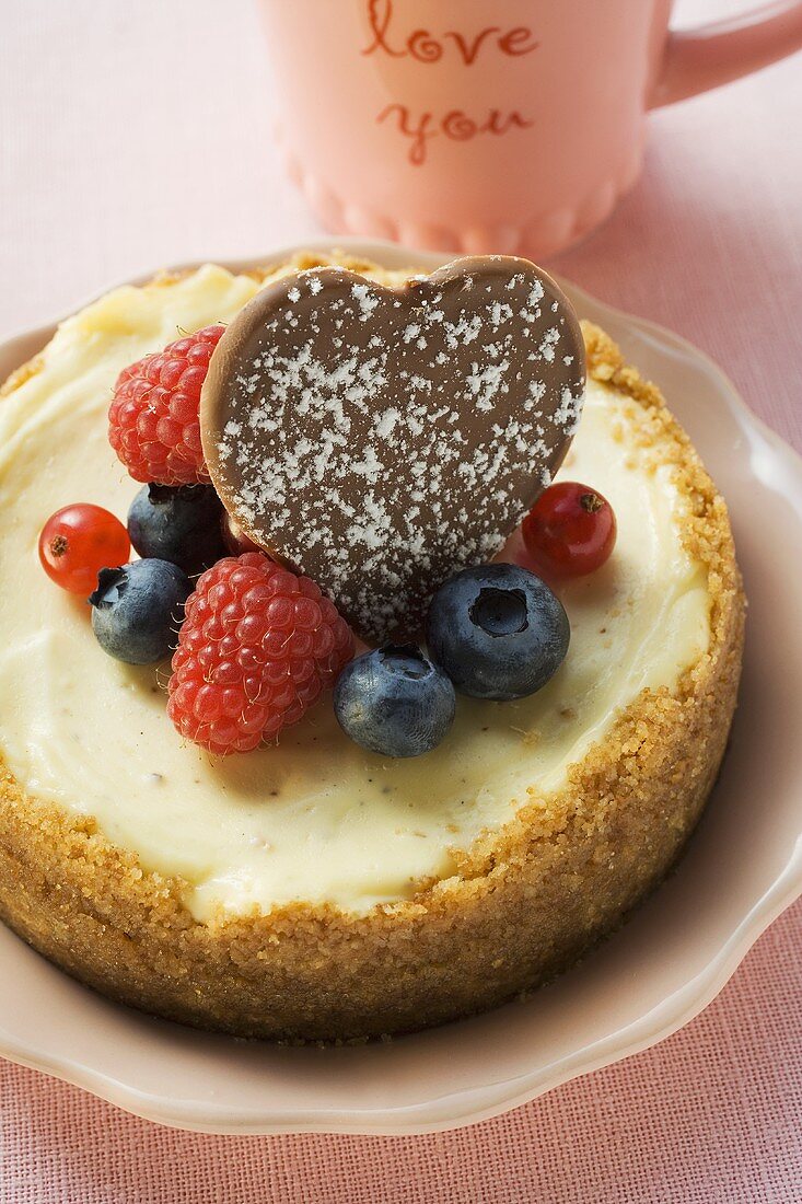 Käsekuchen mit frischen Beeren und Schokoladenherz