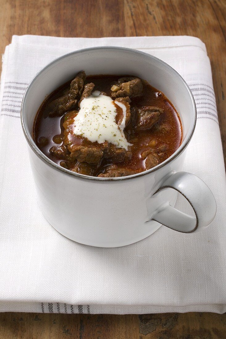 Goulash soup with sour cream in cup
