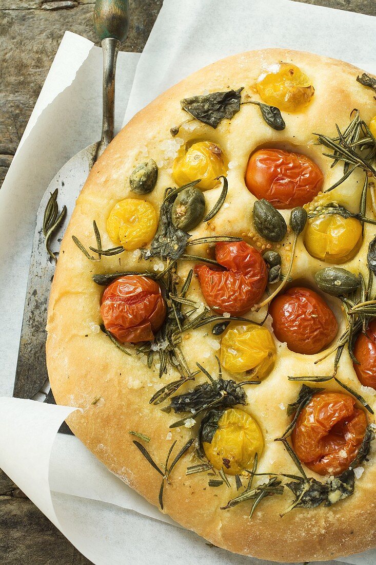 Pizza mit Kirschtomaten, Kapern und Rosmarin